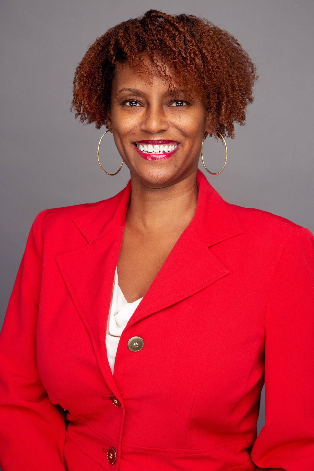 A woman in red jacket smiling for the camera.