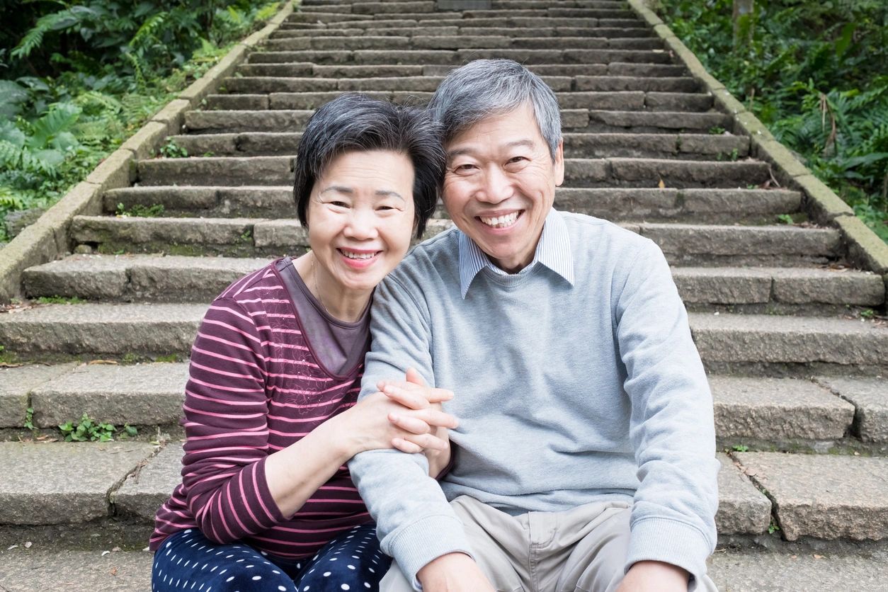 A man and woman sitting on the ground next to some steps.