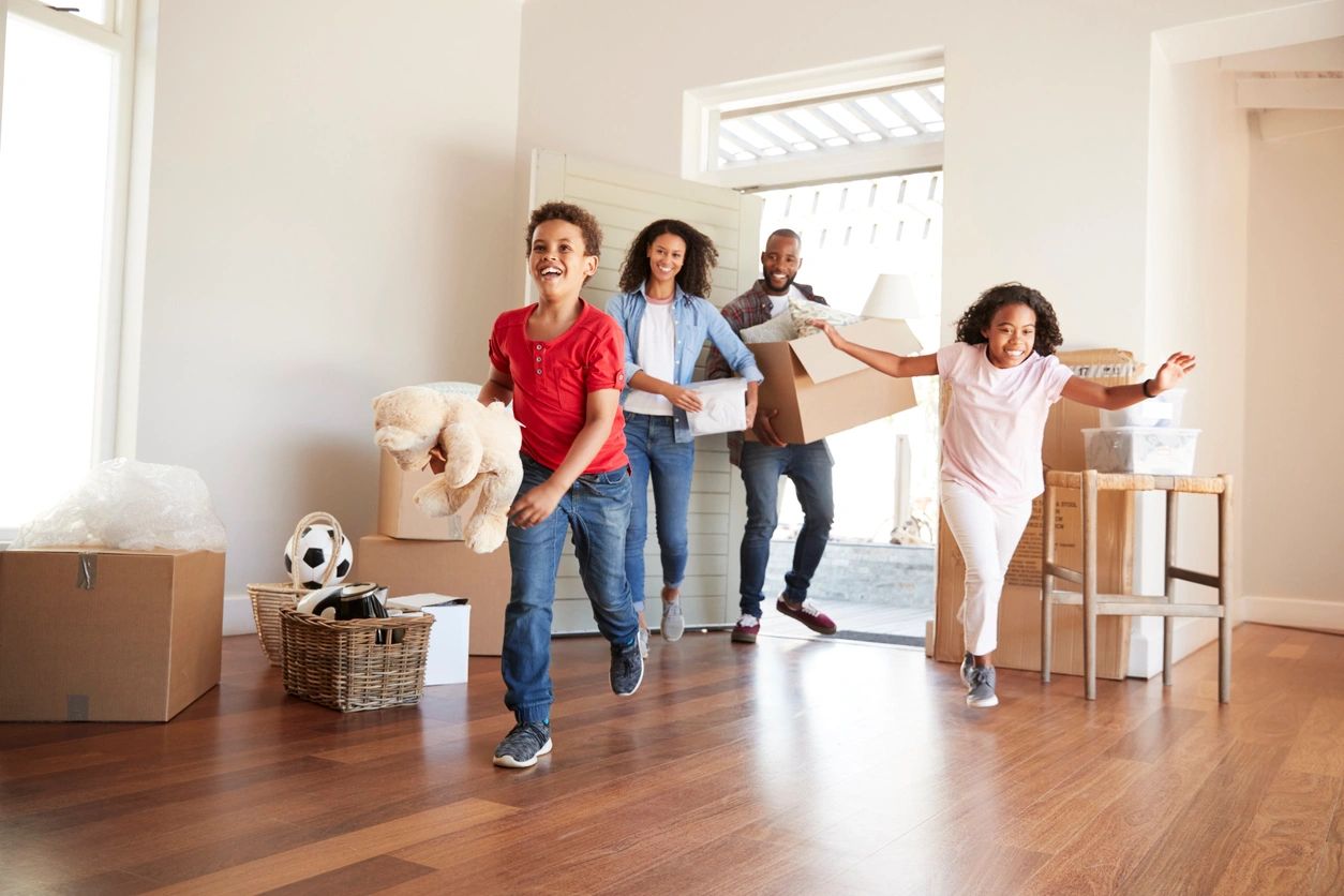 A group of people in the living room moving boxes.