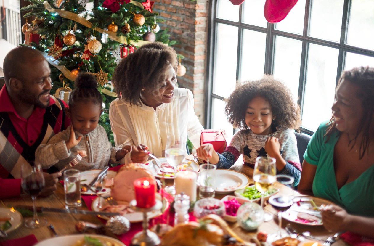 A family sitting at the table eating christmas dinner.