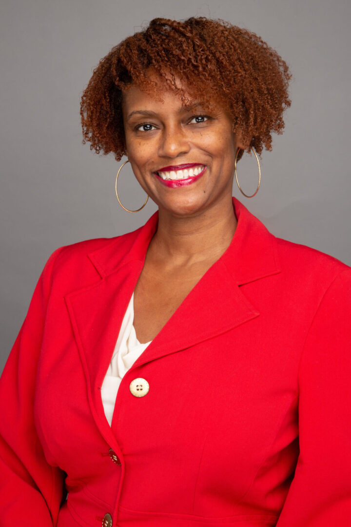 A woman in red jacket smiling for the camera.