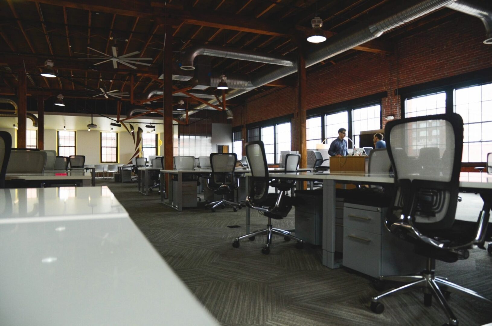 A large open office with many desks and chairs.