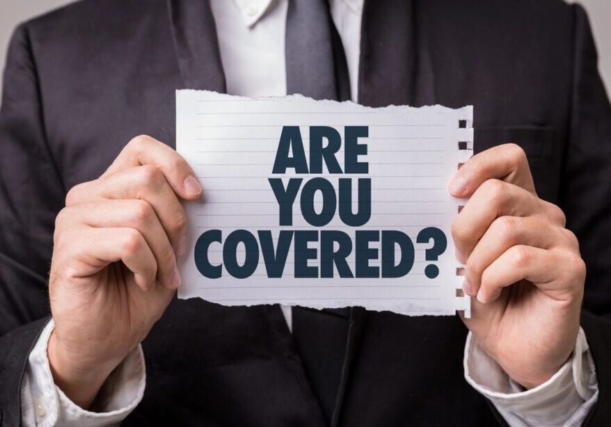 A man holding up a sign that says are you covered