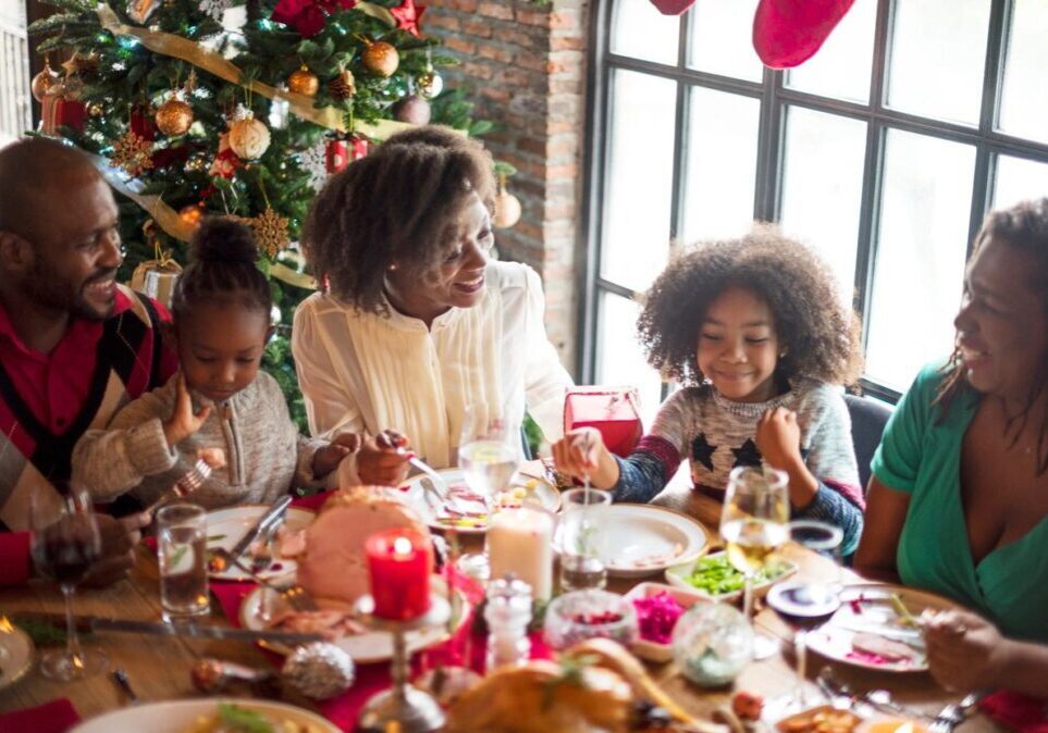 A family sitting at the table eating christmas dinner.