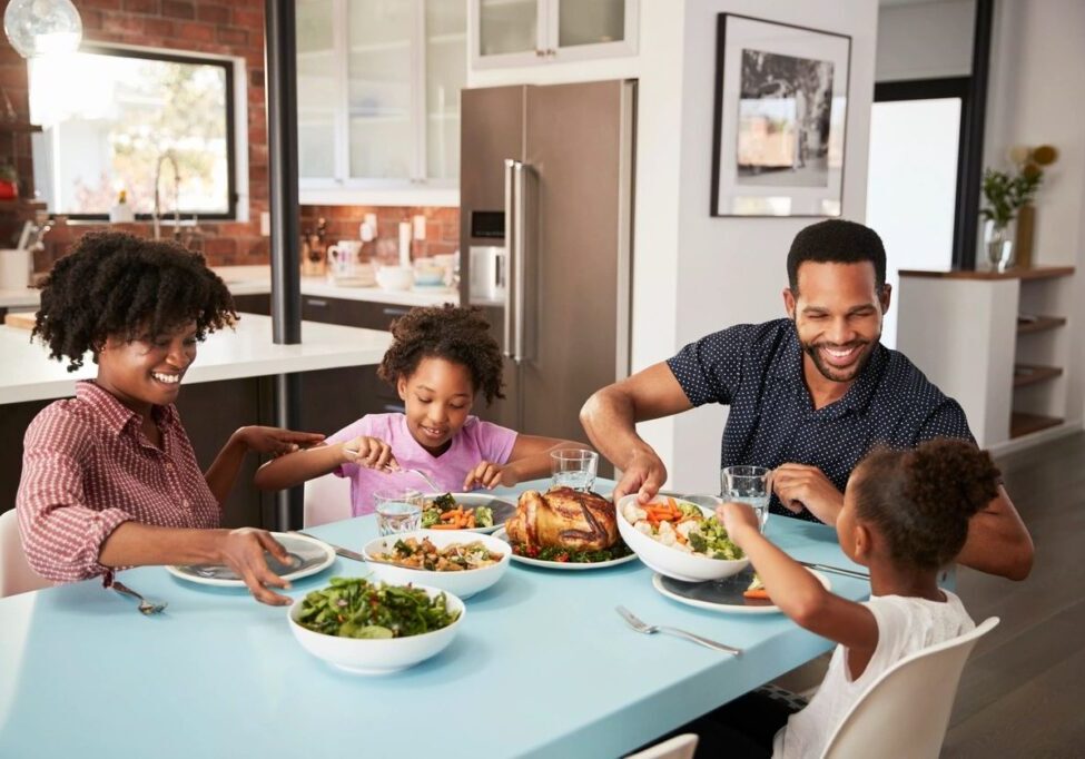 A family sitting at the table eating dinner.