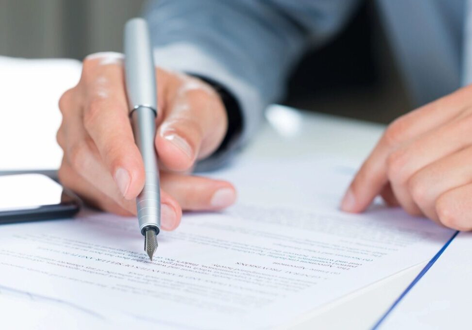 A person is writing on top of a paper.