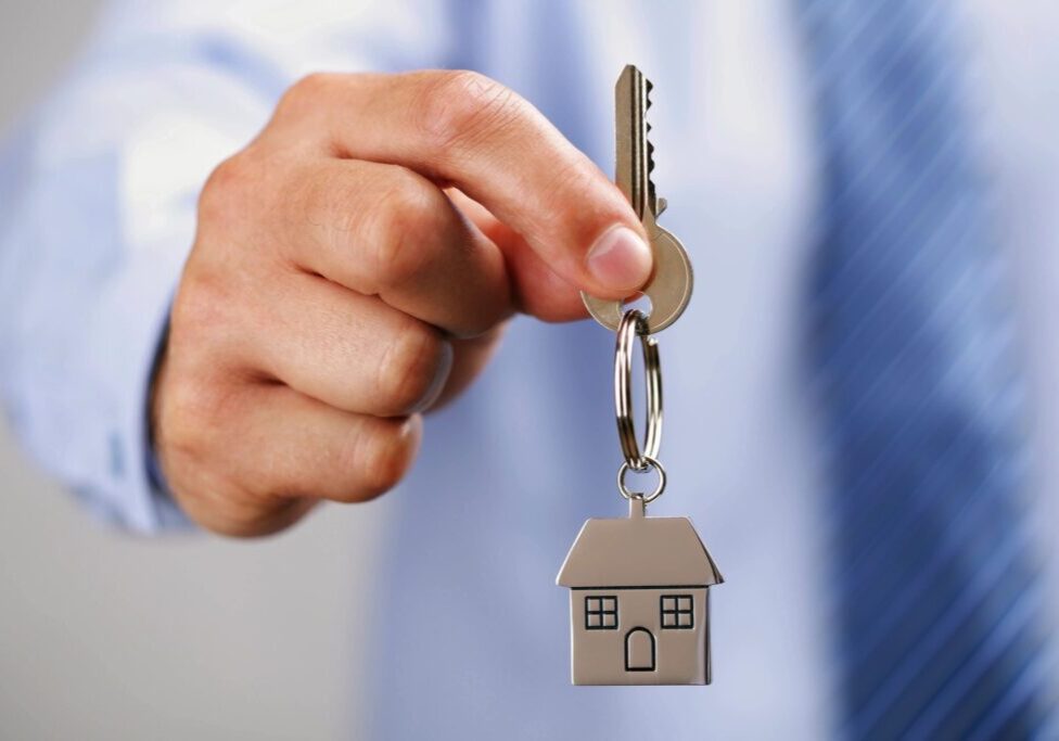 A person holding keys to a house.