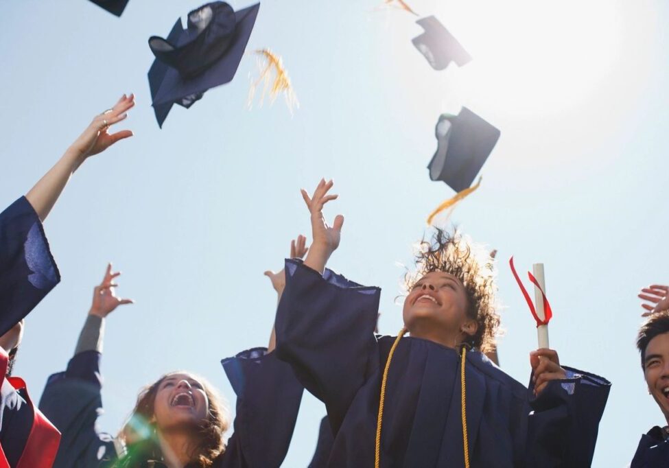 A group of people throwing their caps in the air.