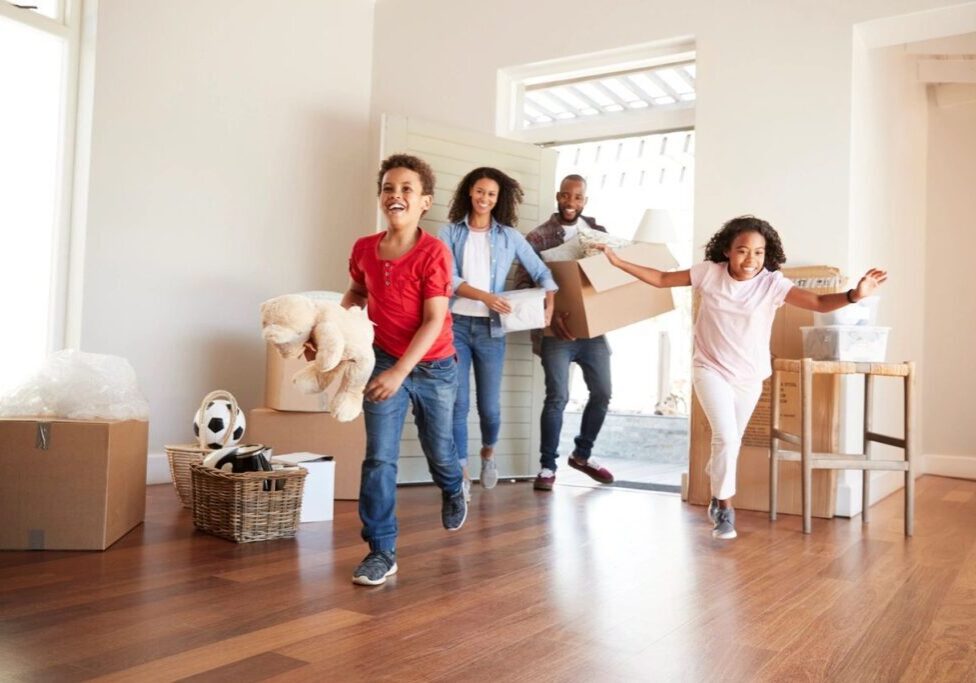 A group of people in the living room moving boxes.