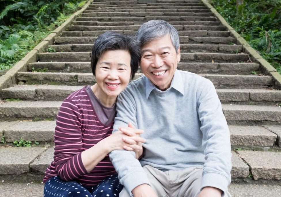 A man and woman sitting on the ground next to some steps.