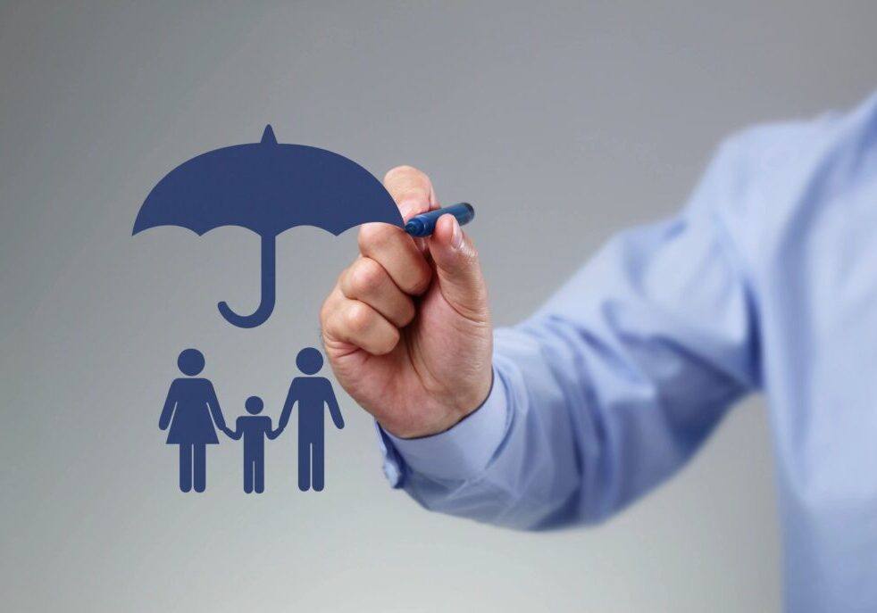 A person drawing an umbrella over their family.