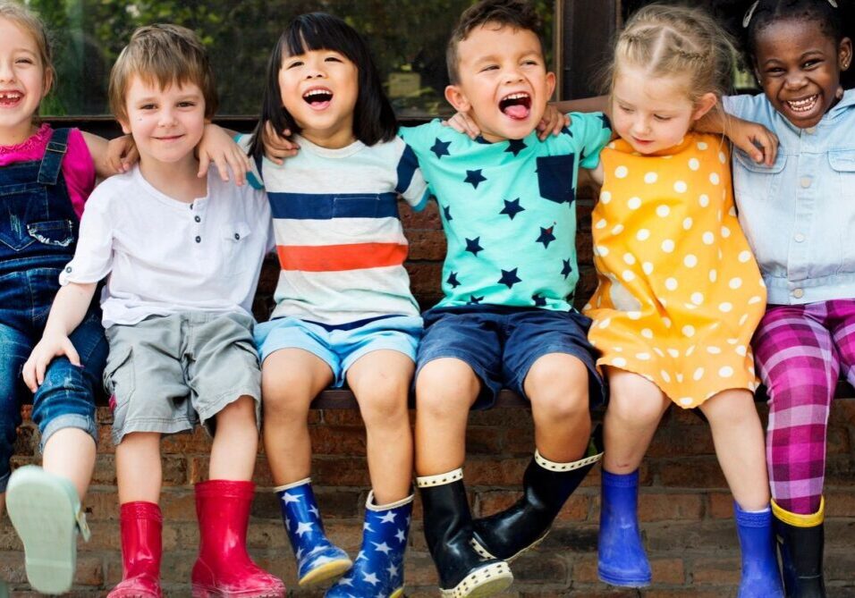 A group of children sitting on top of a bench.